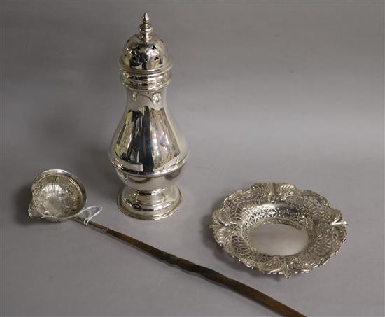 A repousse white metal toddy ladle with baleen handle, a large silver sugar caster and a repousse silver bonbon dish.